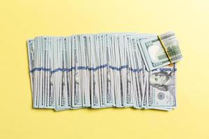 vista superior de mentir notas de 100 dólares em uma linha sobre fundo colorido. close-up do conceito de economia de dinheiro foto