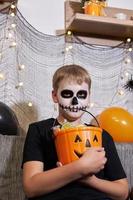 a criança tira o doce do balde para o halloween foto