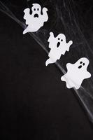 decoração de halloween e conceito de horror - teia de aranha com fantasmas sobre fundo preto foto