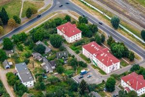 vista panorâmica aérea de uma grande altura de uma pequena cidade verde provincial com setor privado e prédios de apartamentos altos foto