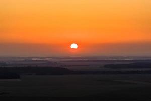 sol vermelho do nascer ou pôr do sol no início da manhã ou à noite foto