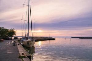 veleiro no porto do lago vaettern ao pôr do sol. farol ao fundo foto