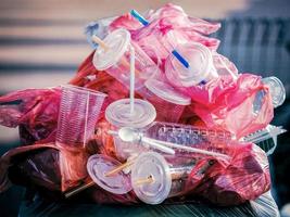 vista de perto de uma pilha de plásticos de uso único empilhados em uma lixeira foto