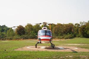 helicóptero estacionado no heliporto perto da floresta.