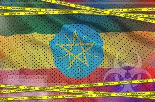 bandeira da etiópia e fita amarela de quarentena covid-19. conceito de vírus coronavírus ou 2019-ncov foto