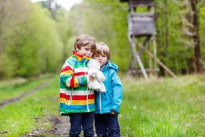 dois meninos caminhando pela floresta em um dia frio foto