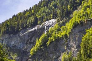 Alpes suíços vistos através da floresta no parque natural blausee foto