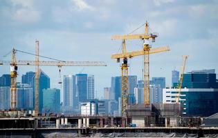 guindaste trabalhando sobre o edifício de construção no fundo da torre e do céu. foto