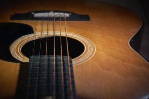 close-up e detalhes do velho violão, linha e curva de instrumento, foco seletivo de cordas de guitarra com escala e pescoço, conceito musical, fundo de guitarra
