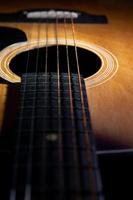 close-up e detalhes do velho violão, linha e curva de instrumento, foco seletivo de cordas de guitarra com escala e pescoço, conceito musical, fundo de guitarra