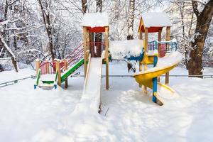 parque infantil público coberto de neve no inverno foto