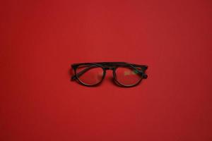 estilo de óculos de moda estilo cartão plástico isolado em fundo vermelho escuro foto