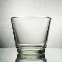 um tiro vertical de um copo vazio em um fundo cinza foto
