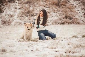 menina usa um chapéu de inverno no cachorro foto