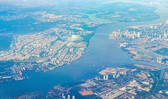 voando acima das nuvens e do aeroporto de paisagem sobre singapura. foto