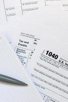 a caneta e o caderno estão no formulário de imposto 1040 nos declaração de imposto de renda individual. hora de pagar impostos foto
