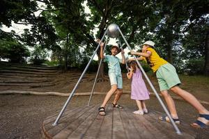 três crianças passeios no playground. centrífuga, balanço para crianças. foto
