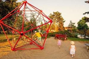 as crianças brincam na escalada de poliedro de corda no playground ao ar livre. foto