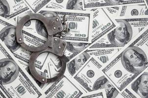 algemas da polícia estão em muitas notas de dólar. o conceito de posse ilegal de dinheiro, transações ilegais com dólares americanos. crime econômico foto