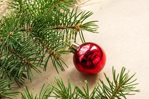 galhos de árvores do abeto decorados com bolas vermelhas de natal como borda em um quadro de fundo de férias rústico com espaço de cópia foto