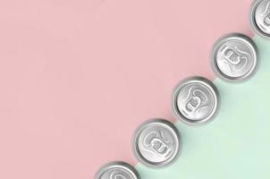 muitas latas de cerveja metálica no fundo de textura de moda pastel turquesa e cores rosa foto