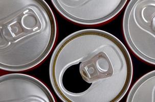 muitas latas de refrigerantes ou recipientes de bebidas energéticas. muitas latas recicladas feitas de alumínio e sendo preparadas para reprodução. foto