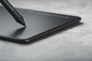 tablet gráfico com um designer de trabalho de caneta, close-up. gadget para criatividade e trabalho de um fotógrafo, ilustrador e artista de arte. foto