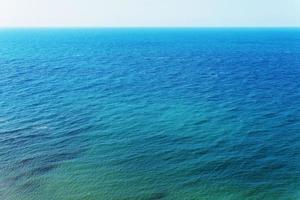 céu azul sobre o mar com reflexo. mar pacífico de textura de harmonia para a água. foto