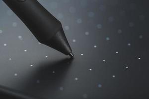 caneta e tablet gráfico close-up em um fundo cinza textural. gadget para trabalhar como designer, artista e fotógrafo. foto