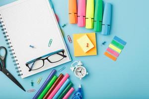 artigos de papelaria para escola e criatividade estão em um fundo azul. foto