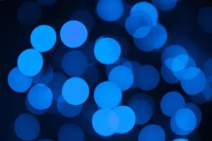 luzes desfocadas. bokeh azul sobre fundo preto. sobreposição de natal e ano novo. espaço de cópia foto