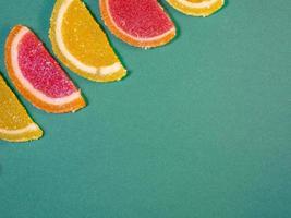 geleia de frutas em forma de fatias de laranja em uma superfície verde foto