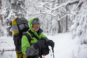 mochileiro posando em montanhas de inverno