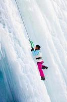 mulher escalando cachoeira congelada