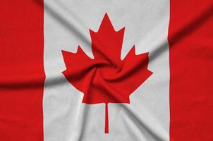 A bandeira do canadá é retratada em um tecido esportivo com muitas dobras. bandeira da equipe esportiva foto