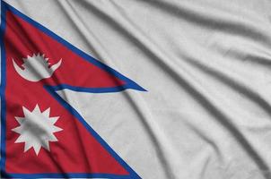 A bandeira do nepal é retratada em um tecido esportivo com muitas dobras. bandeira da equipe esportiva foto