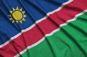 a bandeira da namíbia é retratada em um tecido esportivo com muitas dobras. bandeira da equipe esportiva foto