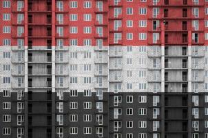 bandeira do iêmen retratada em cores de tinta em prédio residencial de vários andares em construção. banner texturizado no fundo da parede de tijolos foto