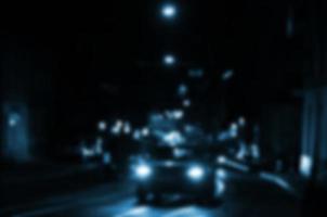 cena noturna turva de tráfego na estrada. imagem desfocada de carros viajando com faróis luminosos. arte bokeh foto
