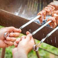 mãos de homem prepara carne de churrasco foto