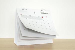 página do calendário, lançando a folha no fundo da mesa de madeira, agenda de negócios, planejamento, reunião, conceito foto