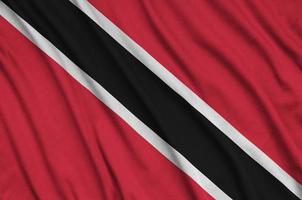 A bandeira de trinidad e tobago é retratada em um tecido esportivo com muitas dobras. bandeira da equipe esportiva foto