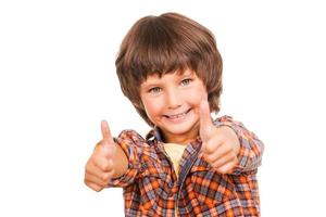 polegares para cima menino feliz mostrando os polegares para cima e sorrindo em pé isolado no branco foto