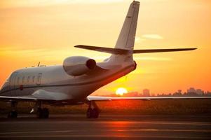 acabou de desembarcar. avião pousando no aeroporto com pôr do sol ao fundo foto