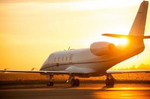 decolando. avião está decolando do aeroporto com pôr do sol ao fundo foto