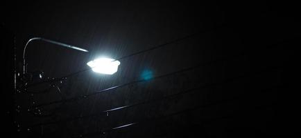 chovendo noite e luz. gotas de chuva caindo à noite em bangkok tailândia na estação chuvosa de agosto. foto