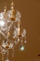 candelabro de cristal de teto de luxo em reflexos brilhantes do hotel foto