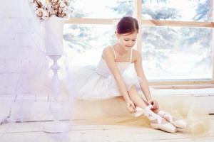 jovem bailarina está se preparando para uma apresentação de balé. pequeno prima balé foto