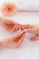 massagem para os dedos. close-up de massagista massageando os dedos do cliente feminino foto