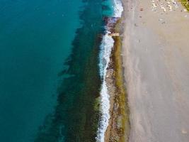 vista aérea do mar, vista de cima, fundo de natureza incrível. cor da água e lindo brilhante. costa rochosa e água clara do mar em um dia ensolarado voando drone, paisagem marinha foto